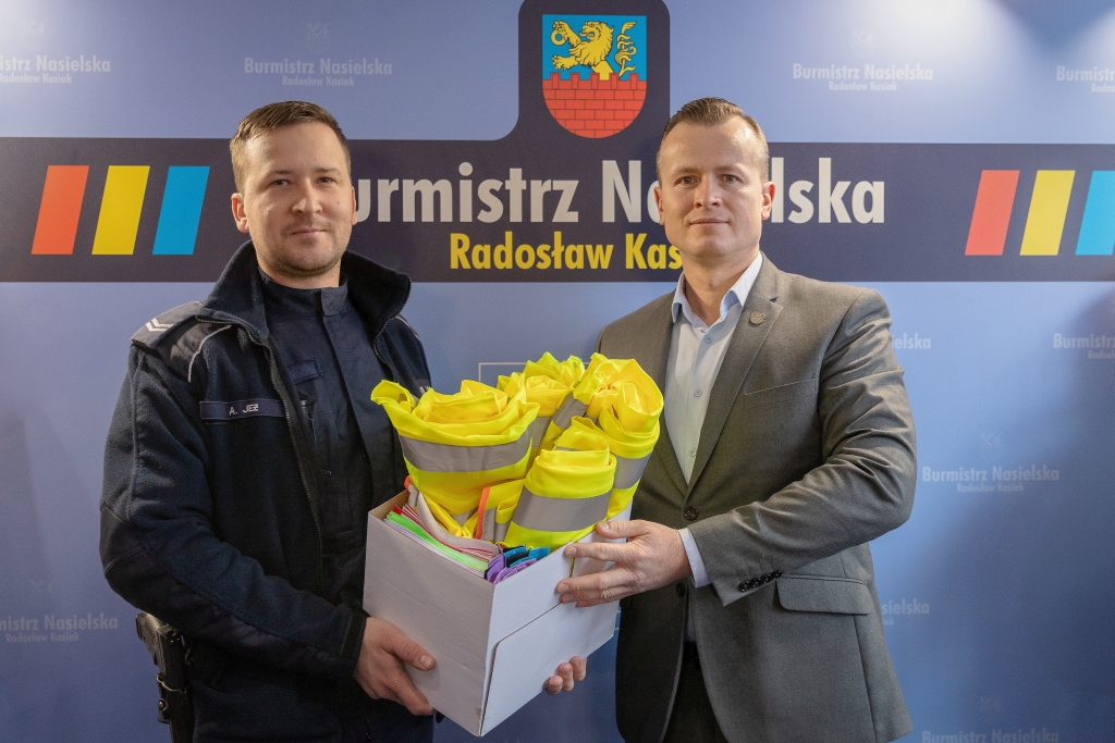 Burmistrz Radosław Kasiak przekazuje elementy odblaskowe